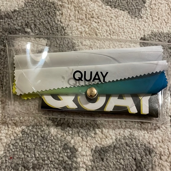 Clear QUAY sunglasses case with blue, green, and yellow cleaner - Picture 1 of 5